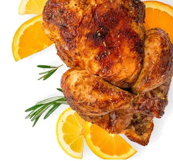 Whole citrus-marinated rotisserie chicken with orange slices and rosemary